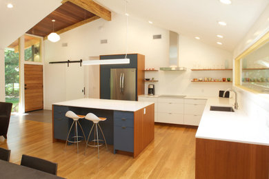 Example of a large 1960s l-shaped light wood floor and beige floor open concept kitchen design in Bridgeport with an undermount sink, flat-panel cabinets, white cabinets, quartz countertops, stainless steel appliances, an island and white countertops