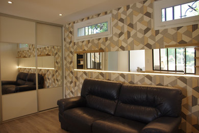 Foto de habitación de invitados actual pequeña sin chimenea con paredes multicolor, suelo de madera clara, suelo marrón y papel pintado