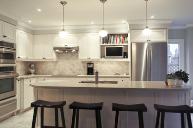 Inspiration for a mid-sized transitional l-shaped porcelain tile eat-in kitchen remodel in Toronto with an undermount sink, white cabinets, quartz countertops, stone tile backsplash, stainless steel appliances, an island, recessed-panel cabinets and gray backsplash