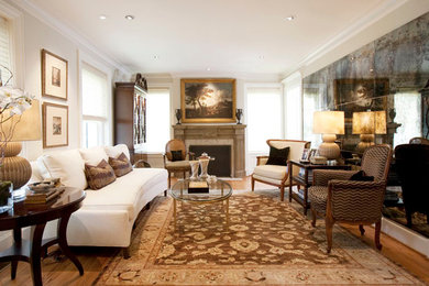 Photo of a mid-sized traditional formal enclosed living room in Houston with white walls, light hardwood floors, a standard fireplace and a wood fireplace surround.