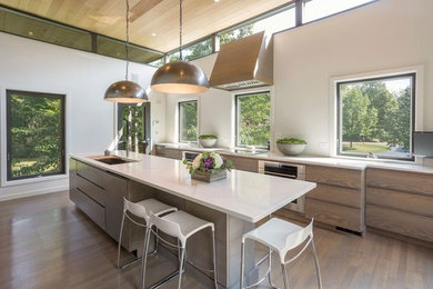 Inspiration for a large contemporary medium tone wood floor kitchen remodel in Chicago with an undermount sink, flat-panel cabinets, medium tone wood cabinets, stainless steel appliances, an island, window backsplash and marble countertops