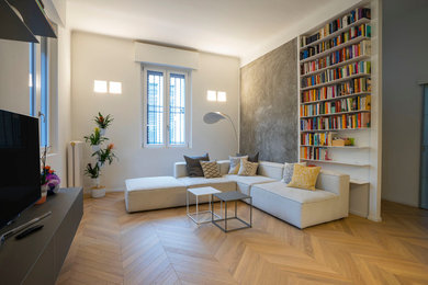Imagen de salón abierto moderno de tamaño medio con paredes blancas, suelo de madera en tonos medios y televisor independiente