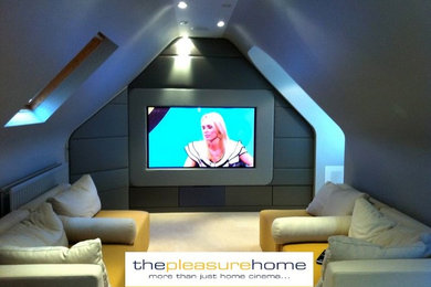 Photo of a small contemporary enclosed home cinema with grey walls, carpet, a built-in media unit and beige floors.
