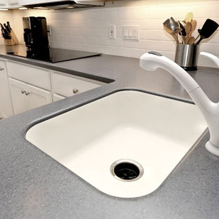 Inspiration för mellanstora maritima kök, med en enkel diskho, vita skåp, bänkskiva i kvarts, vitt stänkskydd, stänkskydd i tunnelbanekakel, rostfria vitvaror, plywoodgolv, en halv köksö, beiget golv och luckor med upphöjd panel