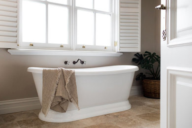 Photo of a mid-sized transitional bathroom in Geelong with beaded inset cabinets, beige cabinets, a freestanding tub, a corner shower, beige tile, travertine, beige walls, travertine floors, a drop-in sink, wood benchtops, beige floor, a hinged shower door, brown benchtops, a niche, a single vanity and a built-in vanity.