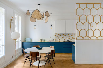 Mid-sized scandinavian open plan dining in Paris with white walls, brown floor, light hardwood floors and no fireplace.