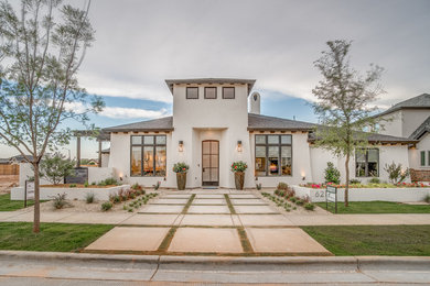 Inspiration for a large mediterranean white one-story stucco exterior home remodel in Austin with a hip roof