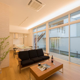 Kleines, Offenes Asiatisches Wohnzimmer mit weißer Wandfarbe, braunem Holzboden und braunem Boden in Sonstige