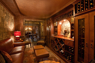 This is an example of a traditional wine cellar in Las Vegas with dark hardwood floors and storage racks.