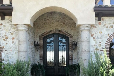 Large beige two-story stone exterior home photo in Other