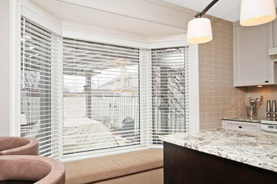 Example of a mid-sized transitional l-shaped light wood floor eat-in kitchen design in Toronto with an undermount sink, shaker cabinets, dark wood cabinets, granite countertops, beige backsplash, stainless steel appliances and two islands