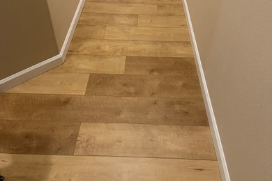 Mid-sized elegant vinyl floor, multicolored floor, vaulted ceiling and wall paneling hallway photo in Los Angeles with beige walls