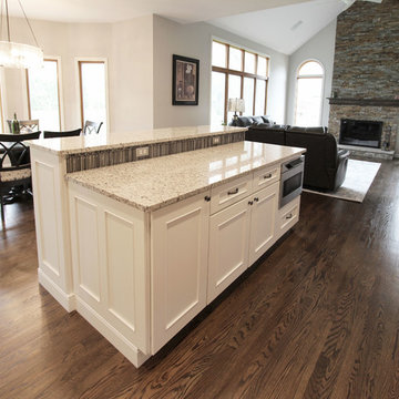 Two Toned Kitchen with White Island and Great Room Stacked Stone Fireplace