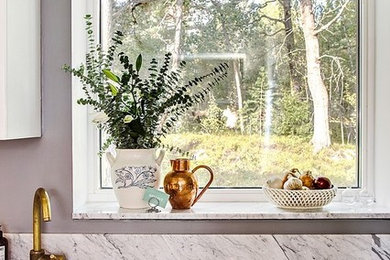 Foto på ett avskilt, mellanstort skandinaviskt kök, med en nedsänkt diskho, släta luckor, vita skåp, marmorbänkskiva, vitt stänkskydd och stänkskydd i marmor