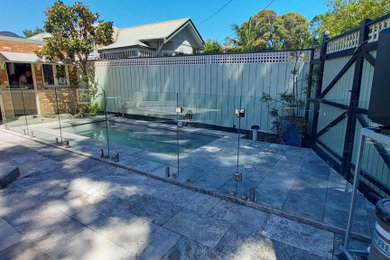 Photo of a mid-sized backyard pool in Melbourne with with a pool and natural stone pavers.