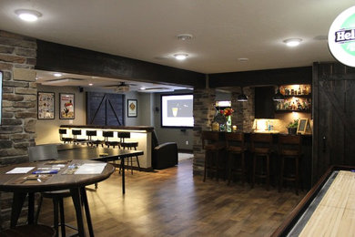 Large mountain style underground medium tone wood floor and brown floor basement photo in Other with gray walls