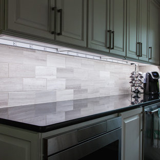 Zweizeilige, Große Klassische Küche mit Vorratsschrank, Unterbauwaschbecken, profilierten Schrankfronten, weißen Schränken, Quarzit-Arbeitsplatte, bunter Rückwand, Kalk-Rückwand, Küchengeräten aus Edelstahl, braunem Holzboden, Kücheninsel und braunem Boden in Wichita