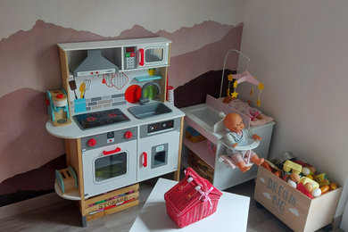 Cette photo montre une chambre d'enfant de 4 à 10 ans avec un mur rose, sol en stratifié et du papier peint.