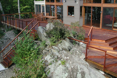 This is an example of a mid-sized country backyard patio in New York with decking and no cover.