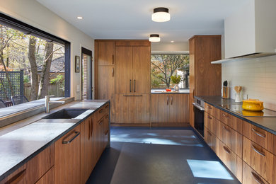 Inspiration for a midcentury kitchen in DC Metro with an integrated sink, flat-panel cabinets, medium wood cabinets, soapstone benchtops, white splashback, ceramic splashback, stainless steel appliances, linoleum floors, blue floor and grey benchtop.