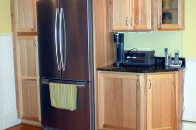Mid-sized elegant l-shaped medium tone wood floor kitchen pantry photo in Other with an undermount sink, shaker cabinets, light wood cabinets, quartz countertops, stainless steel appliances, no island and black countertops