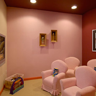 This is an example of an enclosed home cinema in DC Metro with pink walls, carpet and a wall mounted tv.
