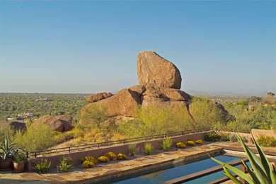 Example of a southwest backyard stone and rectangular hot tub design in Phoenix