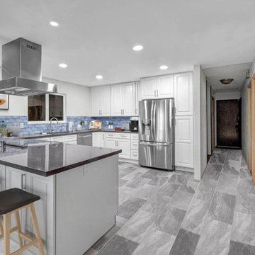 Spacious Coastal-Inspired Kitchen with White Cabinetry and Blue Subway Tile