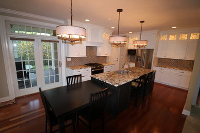 Inspiration for a large timeless u-shaped medium tone wood floor and brown floor eat-in kitchen remodel in Louisville with shaker cabinets, white cabinets, granite countertops, brown backsplash, glass tile backsplash, stainless steel appliances, an island, brown countertops and a farmhouse sink