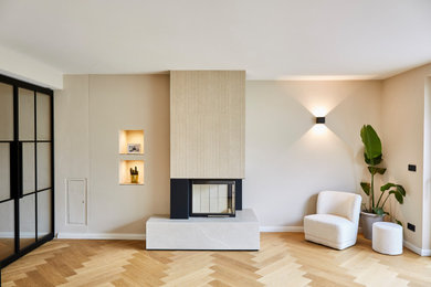 Großes, Repräsentatives, Offenes Modernes Wohnzimmer mit beiger Wandfarbe, hellem Holzboden, Eckkamin und gefliester Kaminumrandung in München