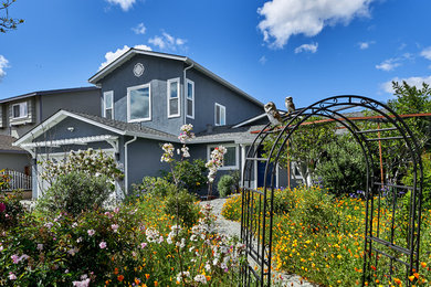 Example of a mid-sized transitional blue two-story stucco exterior home design in San Francisco with a shingle roof