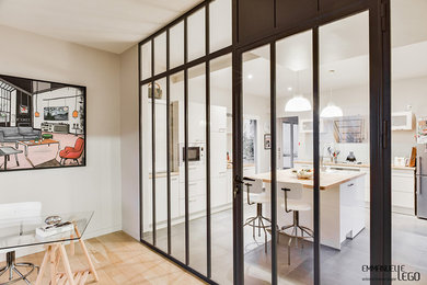 Exemple d'une cuisine encastrable industrielle en L fermée et de taille moyenne avec un placard à porte plane, un plan de travail en bois, parquet clair et îlot.