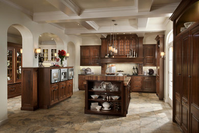 Large elegant u-shaped slate floor enclosed kitchen photo in Chicago with a farmhouse sink, recessed-panel cabinets, dark wood cabinets, wood countertops, beige backsplash, stone tile backsplash, stainless steel appliances and an island
