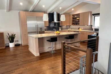 Inspiration for a large contemporary l-shaped medium tone wood floor, brown floor and exposed beam kitchen pantry remodel in New York with an undermount sink, flat-panel cabinets, light wood cabinets, quartzite countertops, blue backsplash, glass tile backsplash, stainless steel appliances, an island and beige countertops