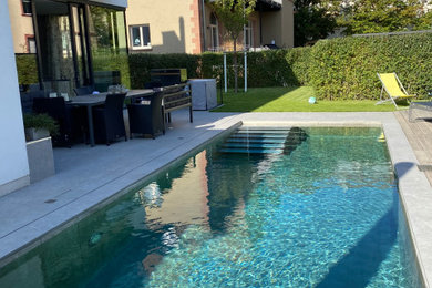 Moderner Pool neben dem Haus in rechteckiger Form mit Betonboden in Sonstige