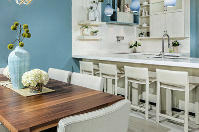 Mid-sized trendy u-shaped porcelain tile and white floor open concept kitchen photo in San Diego with an undermount sink, flat-panel cabinets, light wood cabinets, quartz countertops, white backsplash, ceramic backsplash, stainless steel appliances, a peninsula and white countertops