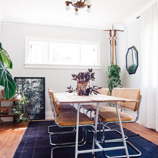 Exemple d'une salle à manger éclectique avec un mur blanc et un sol en bois clair.