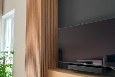 Bild på ett funkis allrum, med svarta väggar, en öppen hörnspis, en spiselkrans i gips och en fristående TV