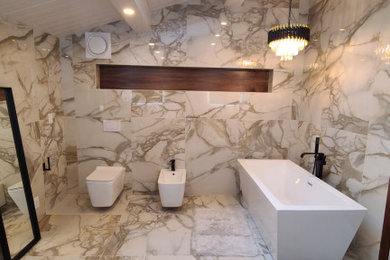 Large minimalist master white tile and marble tile marble floor, white floor, double-sink and vaulted ceiling bathroom photo in Portland with flat-panel cabinets, medium tone wood cabinets, a wall-mount toilet, white walls, a vessel sink, quartz countertops, black countertops, a niche and a floating vanity