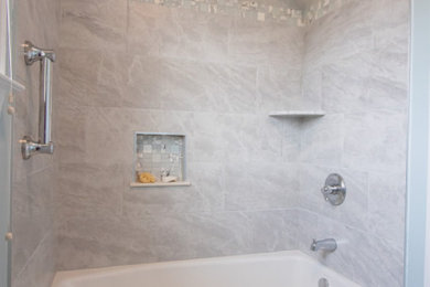 Small transitional gray tile and porcelain tile single-sink, porcelain tile and gray floor bathroom photo in Baltimore with white cabinets, quartz countertops, a built-in vanity, a two-piece toilet, blue walls, an undermount sink, gray countertops and a niche