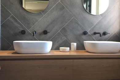Inspiration for a modern bathroom in Other with flat-panel cabinets, white cabinets, an open shower, gray tile, a vessel sink, wood benchtops, a single vanity and a freestanding vanity.
