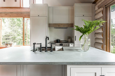 Inspiration for a large rustic u-shaped porcelain tile and gray floor eat-in kitchen remodel in Montreal with an undermount sink, shaker cabinets, concrete countertops, white backsplash, paneled appliances, an island, gray countertops, white cabinets and ceramic backsplash