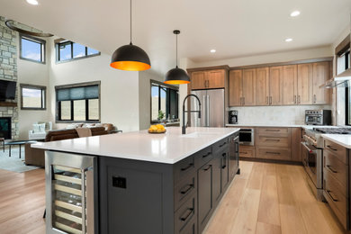 Open concept kitchen - huge rustic l-shaped open concept kitchen idea in Denver with an undermount sink, shaker cabinets, medium tone wood cabinets, stainless steel appliances and an island