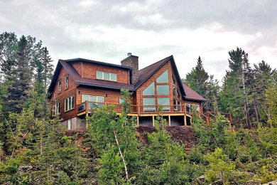 Example of a mid-sized mountain style two-story wood exterior home design