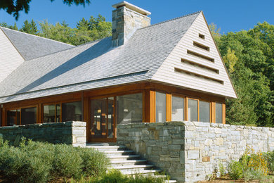 Large contemporary beige two-story wood exterior home idea in Other with a shingle roof