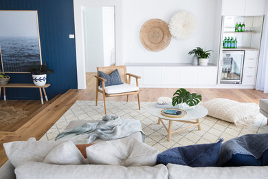 Large beach style open concept living room in Other with white walls, light hardwood floors, no fireplace, a built-in media wall and brown floor.