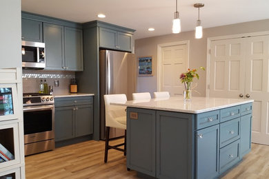 Mid-sized transitional l-shaped separate kitchen in Boston with an undermount sink, recessed-panel cabinets, blue cabinets, solid surface benchtops, beige splashback, glass tile splashback, stainless steel appliances, porcelain floors, beige floor and with island.