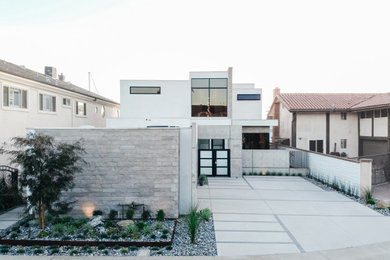 Example of a large urban white two-story concrete exterior home design in Orange County