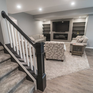 デトロイトの中サイズのモダンスタイルのおしゃれな地下室 (半地下 (ドアあり)、グレーの壁、吊り下げ式暖炉) の写真