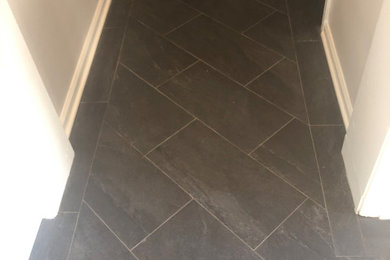Hallway - mid-sized traditional porcelain tile and gray floor hallway idea in New York with white walls
